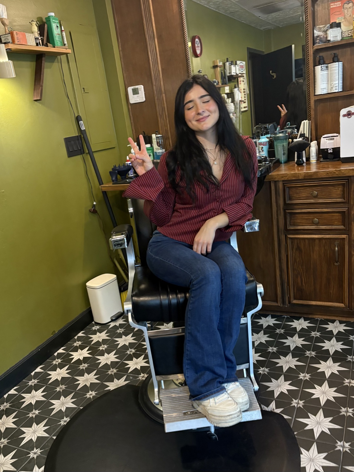 Ari Fernandez seated in a barber chair at River Quay